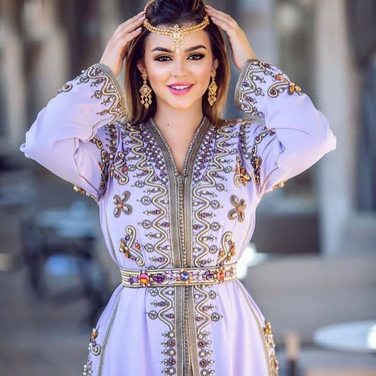 Une femme en robe violette pose pour une photo lors d'une séance de mode de caftan marocain.