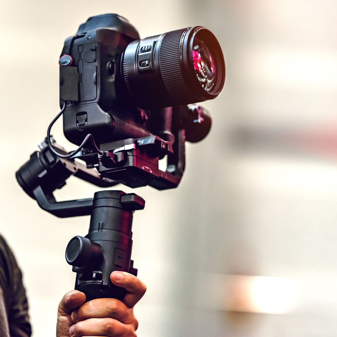 Un homme tenant un appareil photo et une caméra vidéo